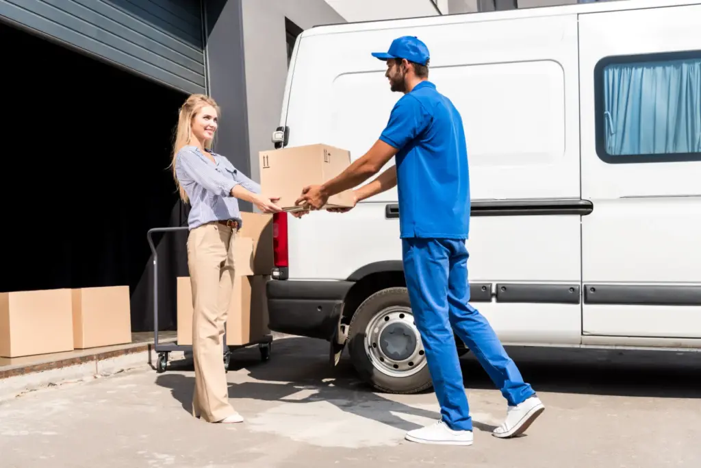 moving company emplyee helping remove a package for a woman