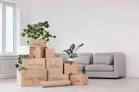 Family packing boxes in a cozy living room, showcasing expert packing tips for a smooth house move